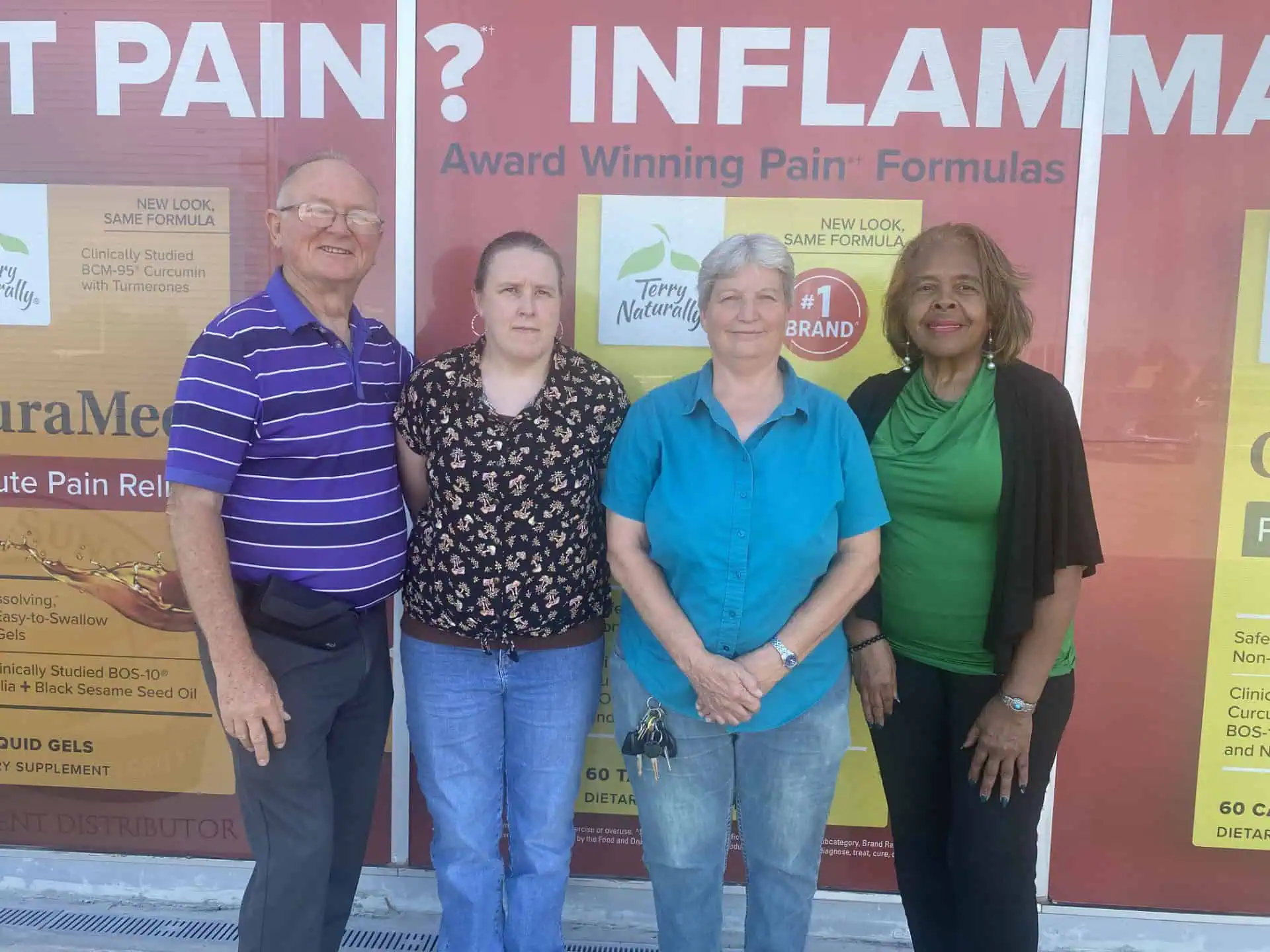 Four adults outside pain-relief storefront